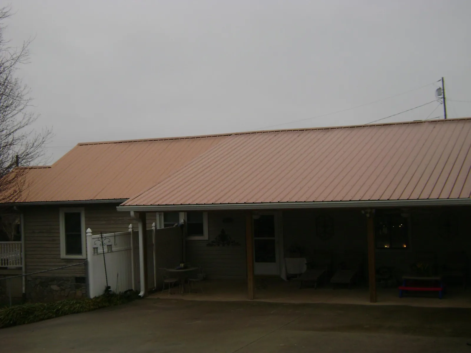 Copper toned metal roof over a wide covered patio in Fairview